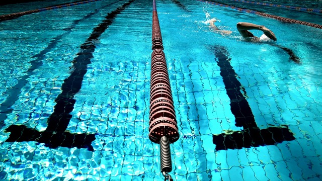 Empty pool lanes with lane ropes seen from water level, ready for a training session